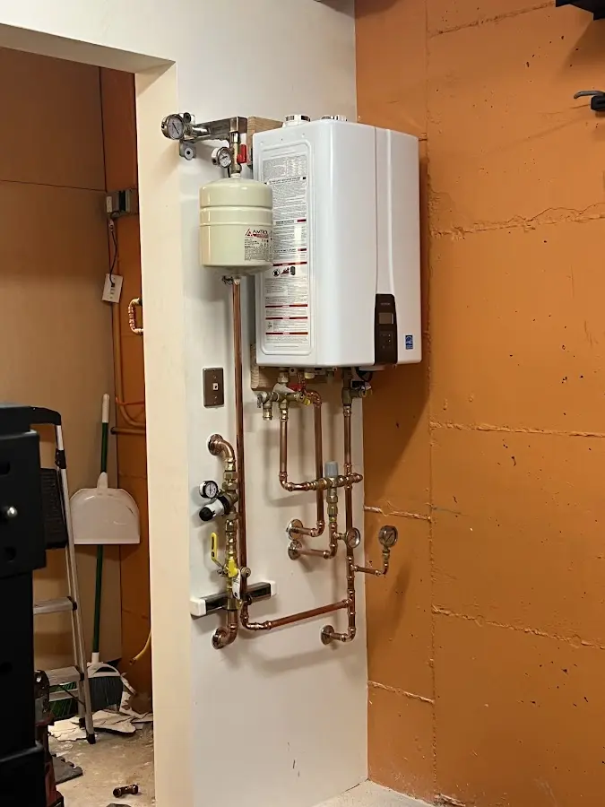 Plumbing technician inspecting water heater connections in Sullivan